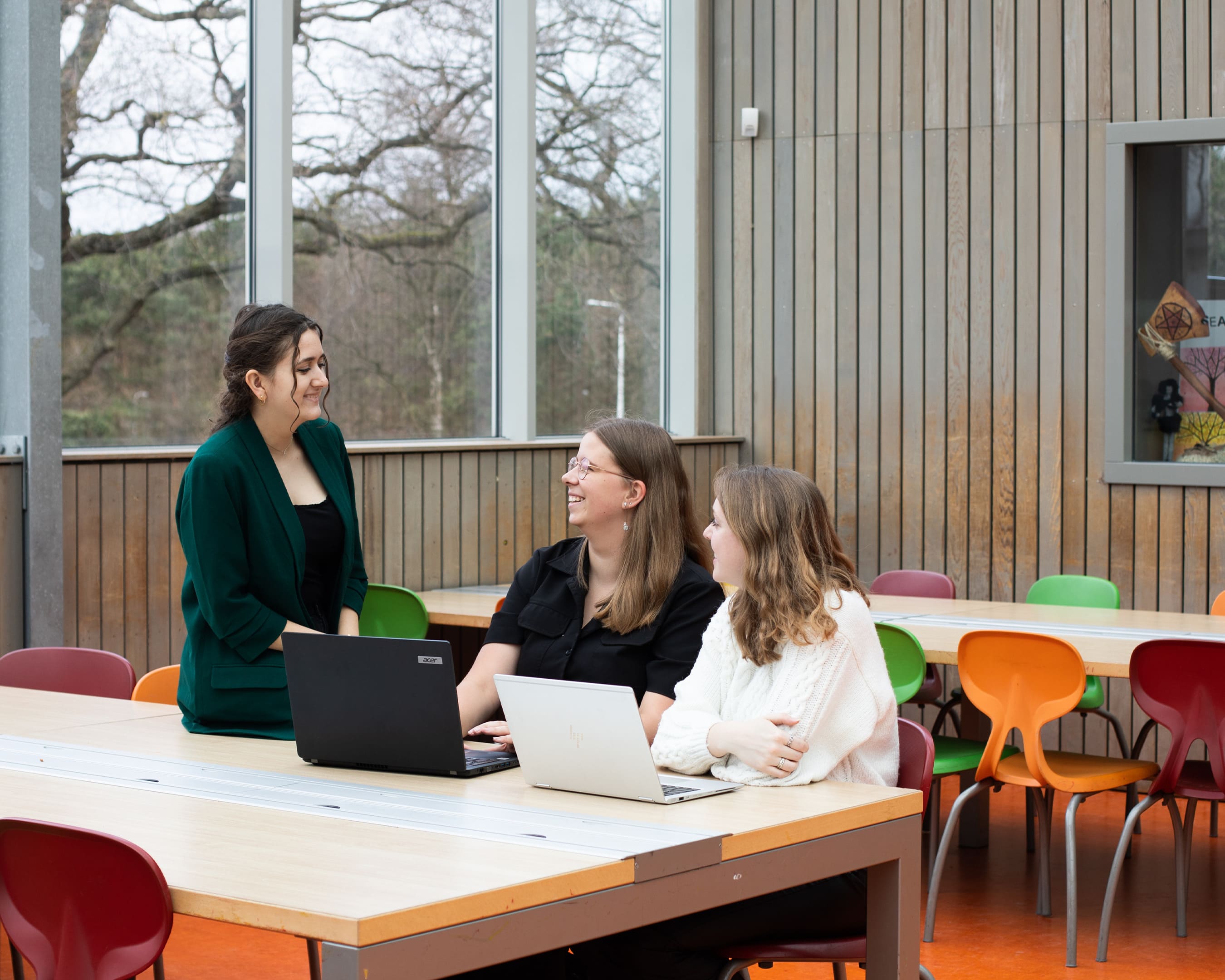 Studenten van opleiding Leraar Omgangskunde zijn  aan het overleggen met een docent.