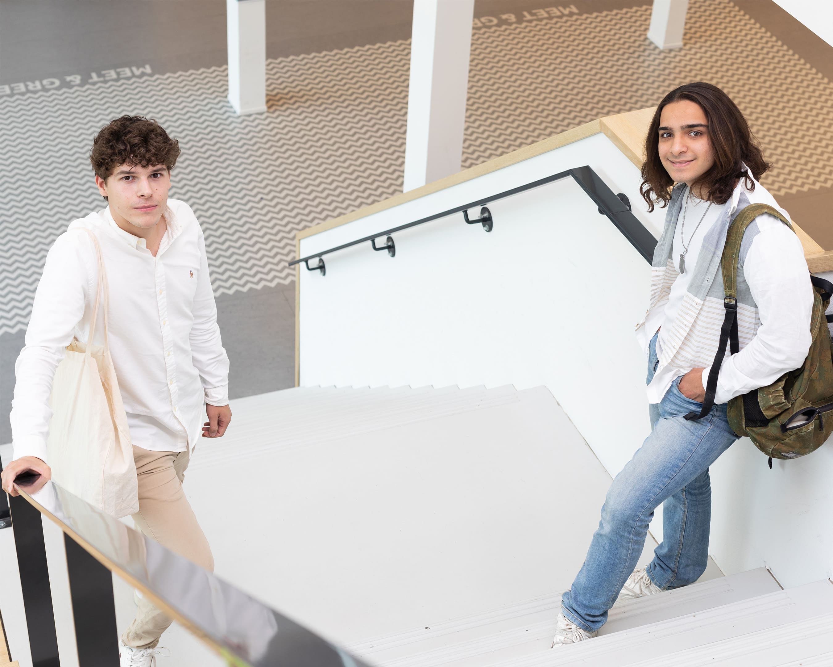 Twee studenten zijn in gesprek en wandelen op de campus van de opleiding Bedrijfskunde