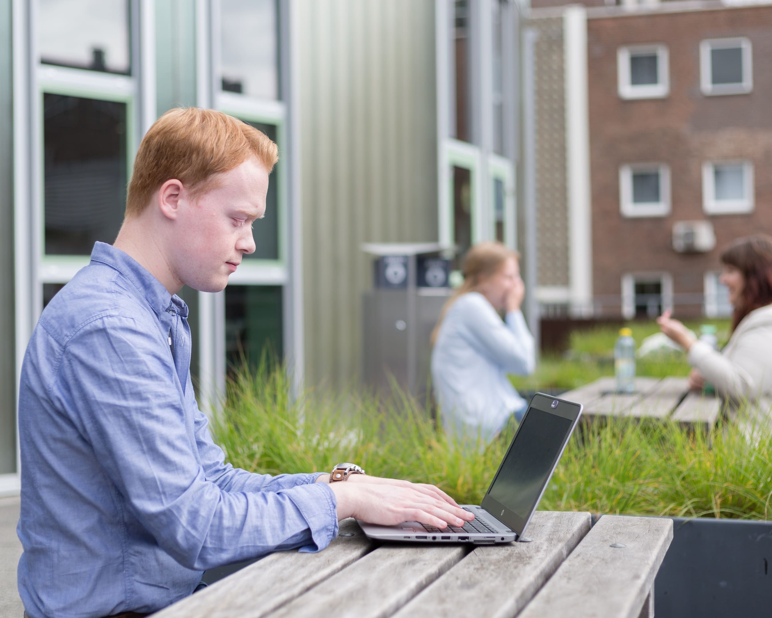 Een student Leraar Biologie werkt buiten aan een laptop