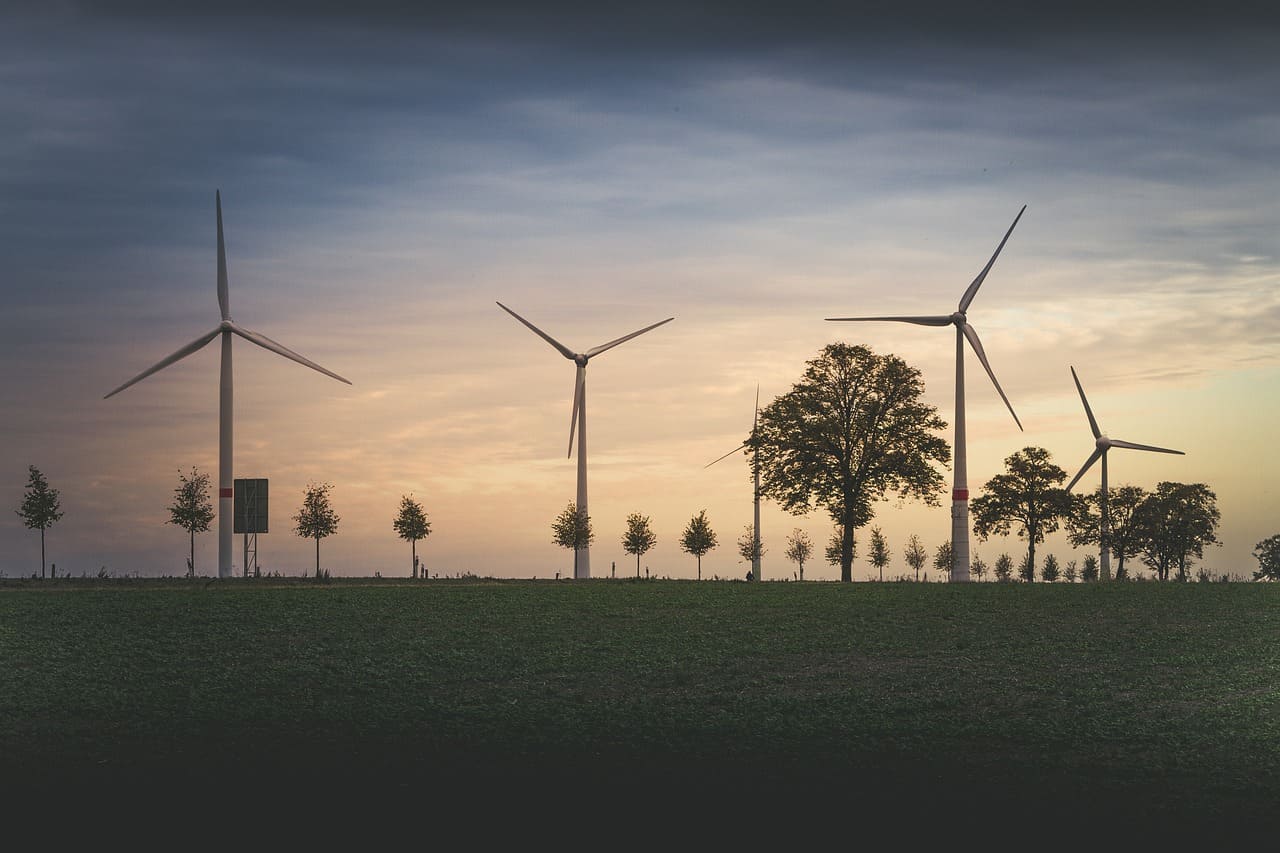 weiland met windmolens en zonsondergang