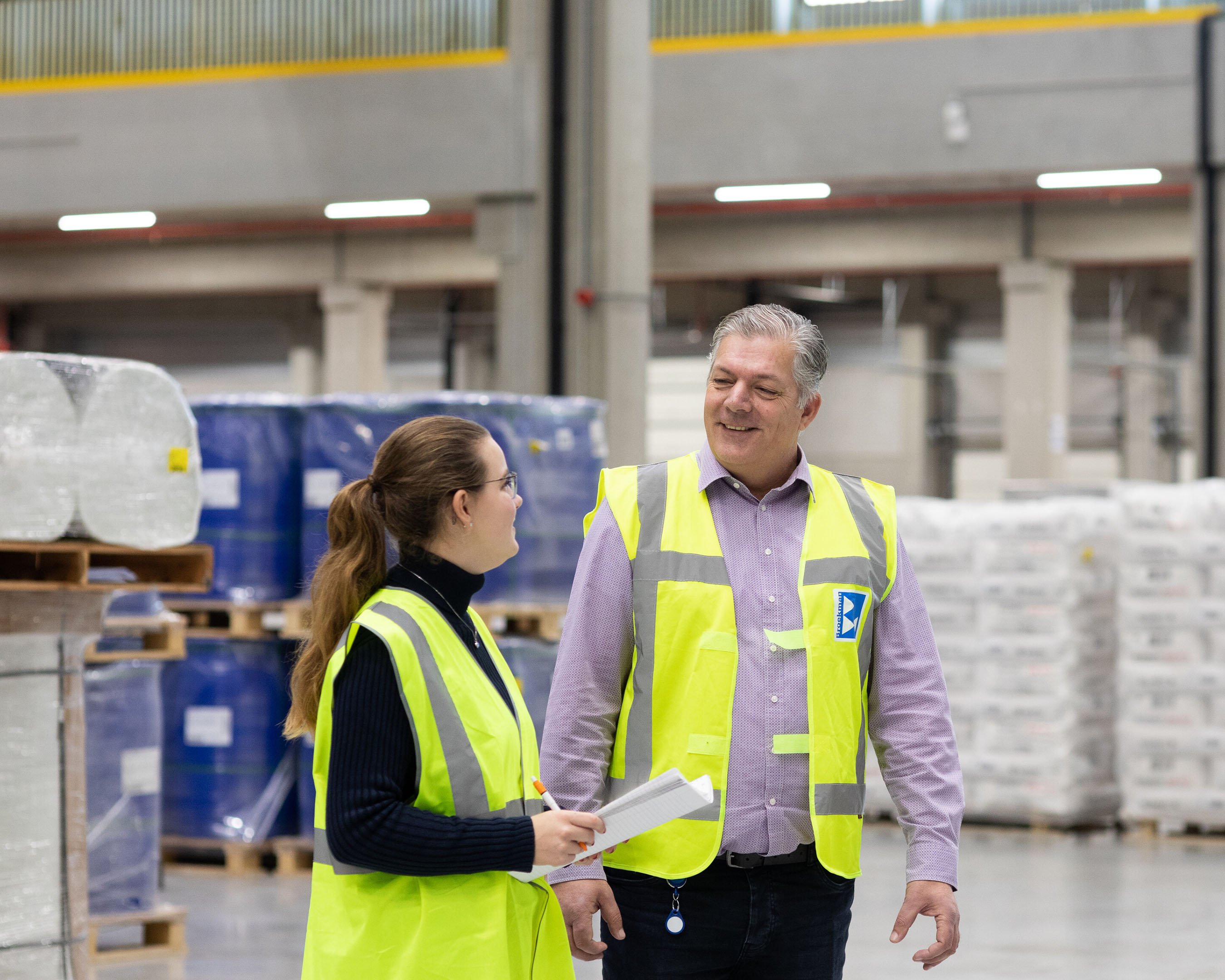 Student logistiek op een bedrijfslocatie in gesprek met werknemer