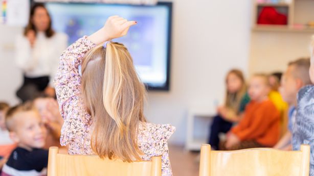 Een kind stelt haar hand op om een vraag te stellen