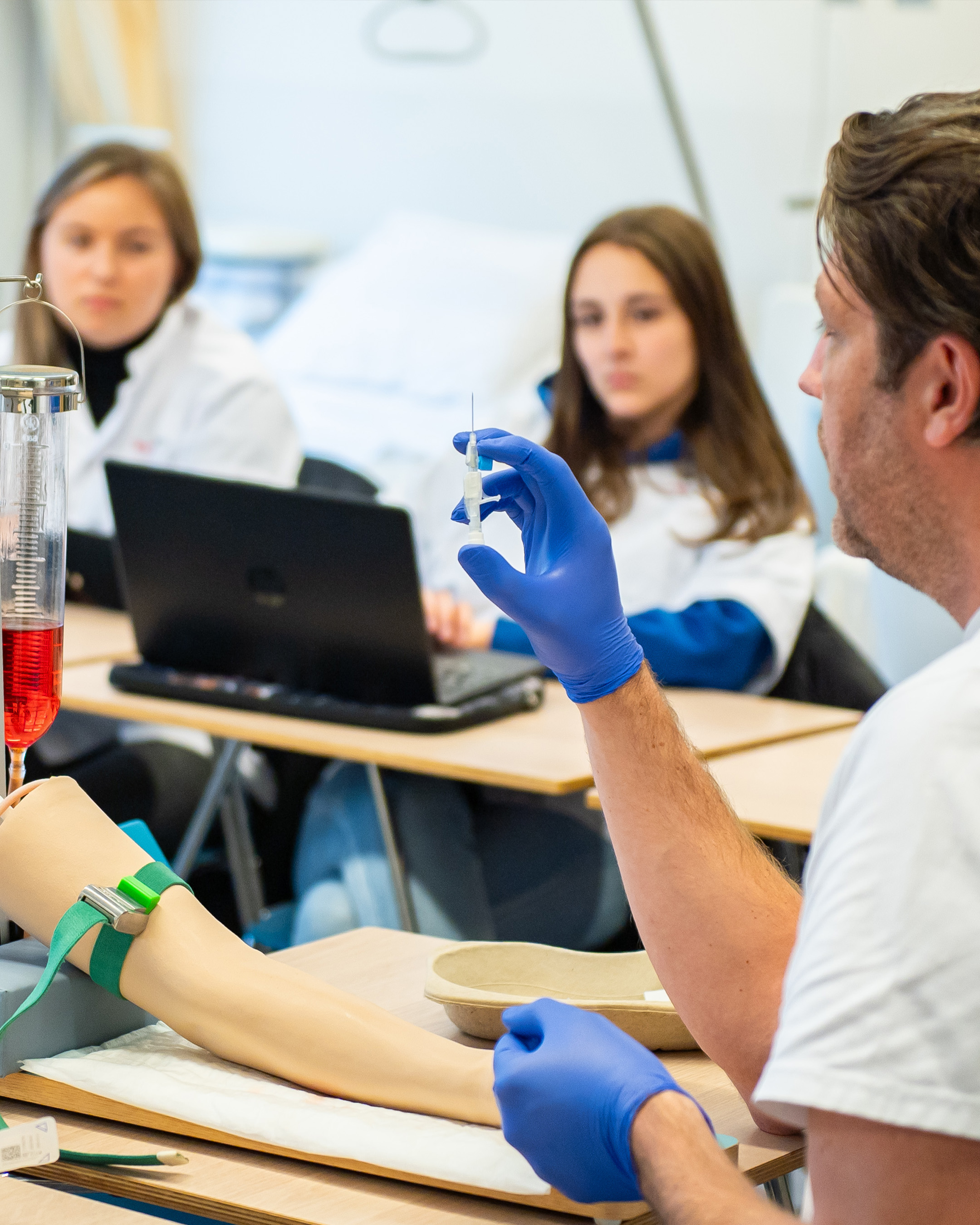 Docent van de deeltijdopleiding Leraar Gezondheidszorg en Welzijn (G&W) geeft uitleg over praktijkoefening