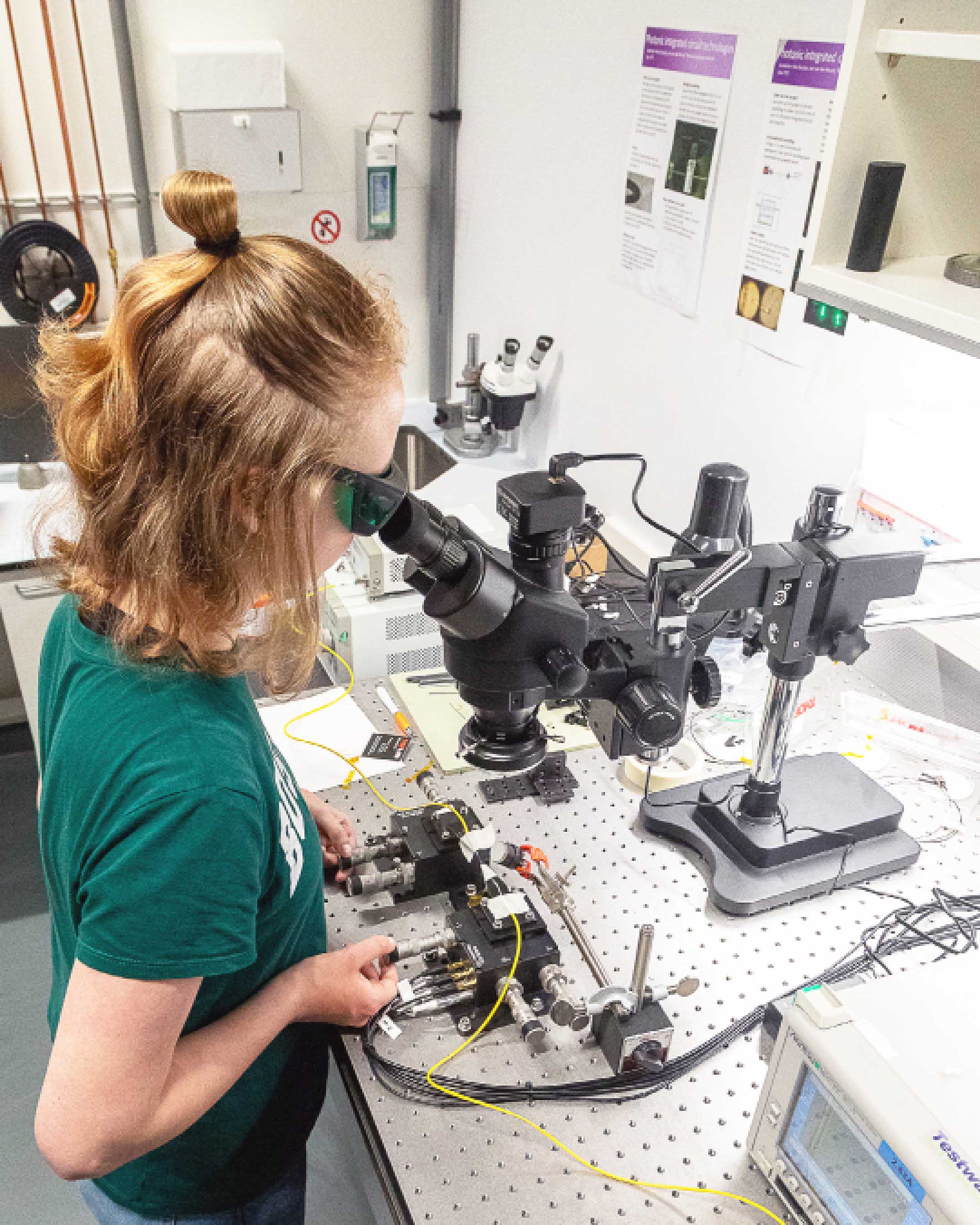 Student Technische Natuurkunde werkt met een microscoop