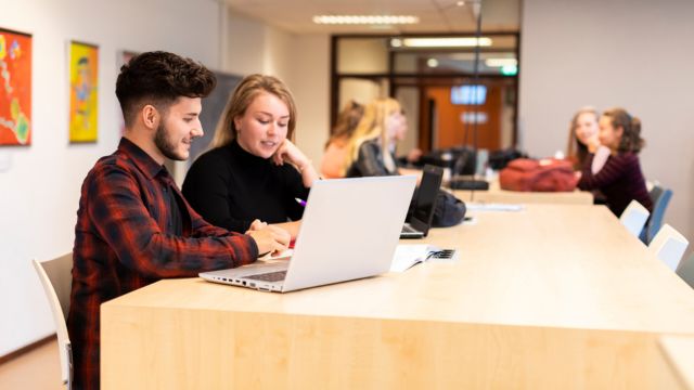 Twee studenten werken achter een laptop