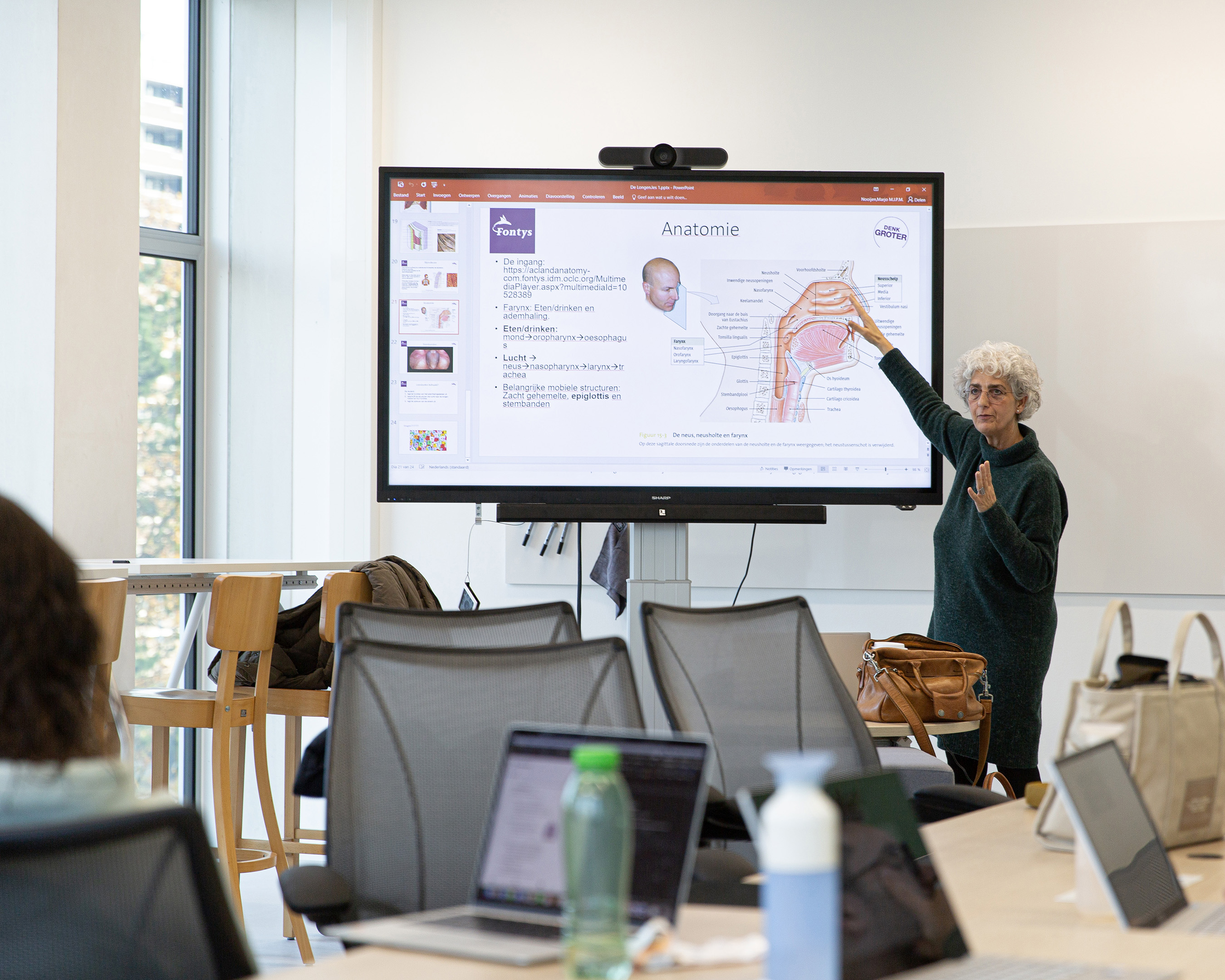 Docent van de opleiding Verpleegkunde legt in de klas wat uit.