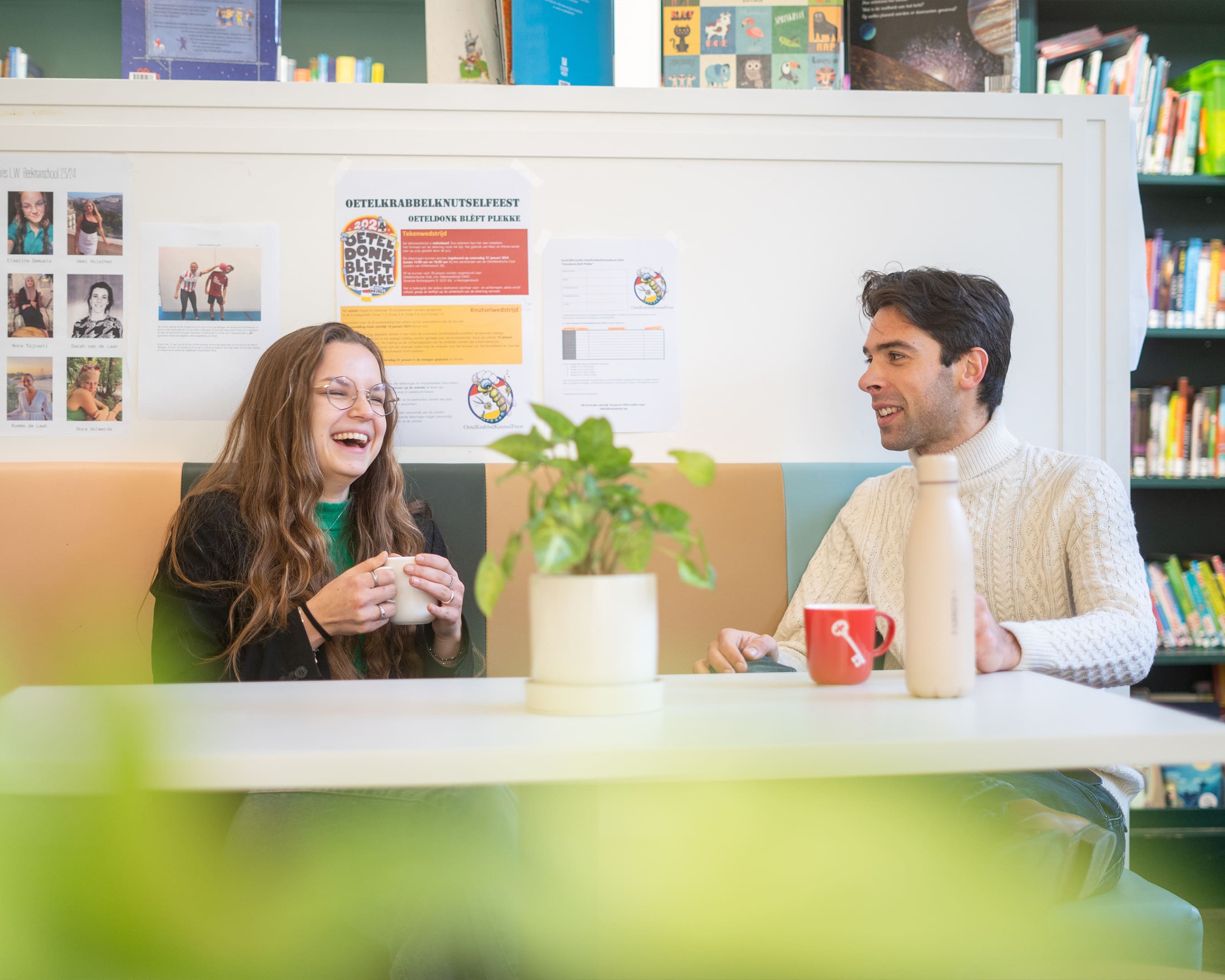 Docent en student in gesprek aan tafel