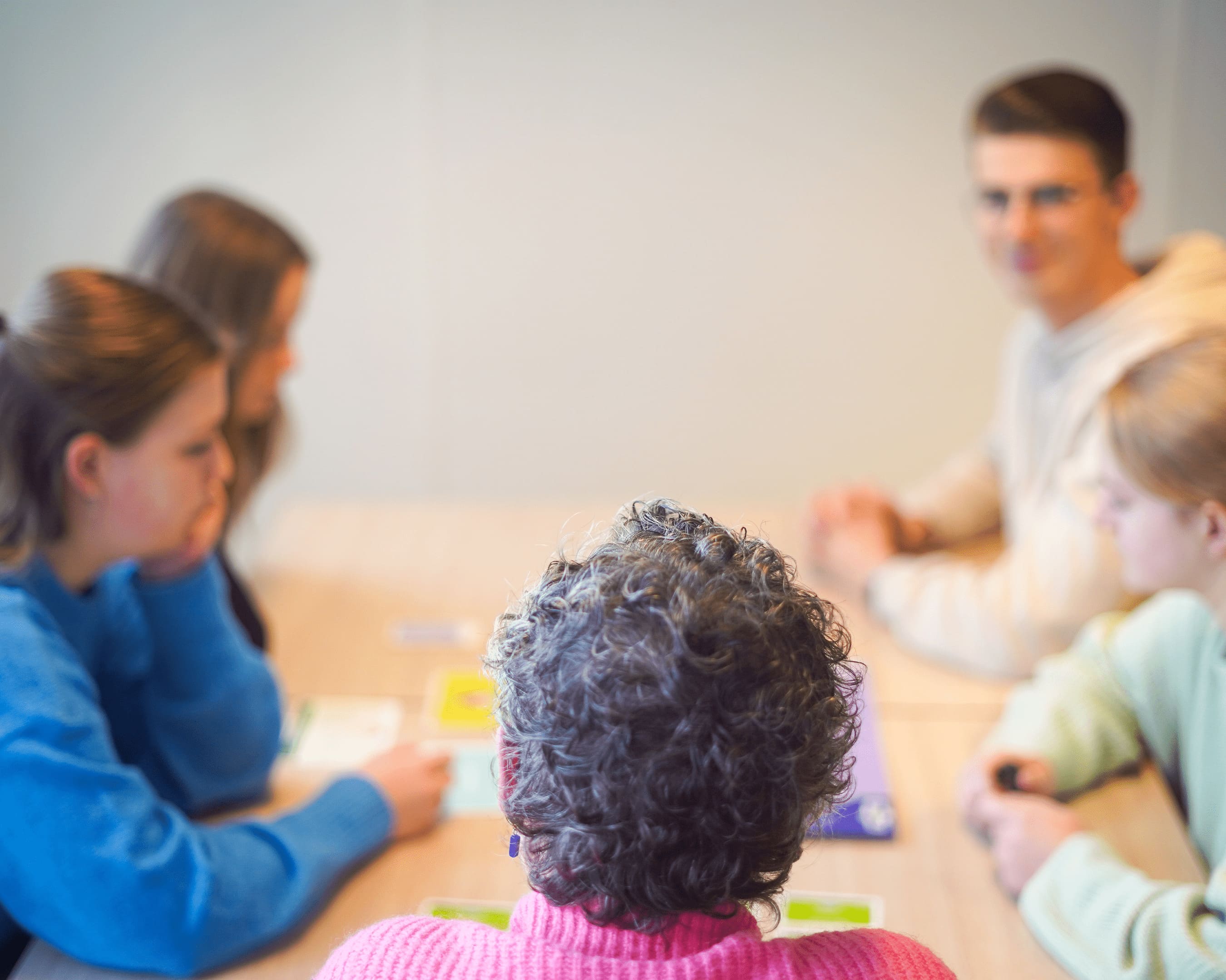 Docent met studenten aan tafel