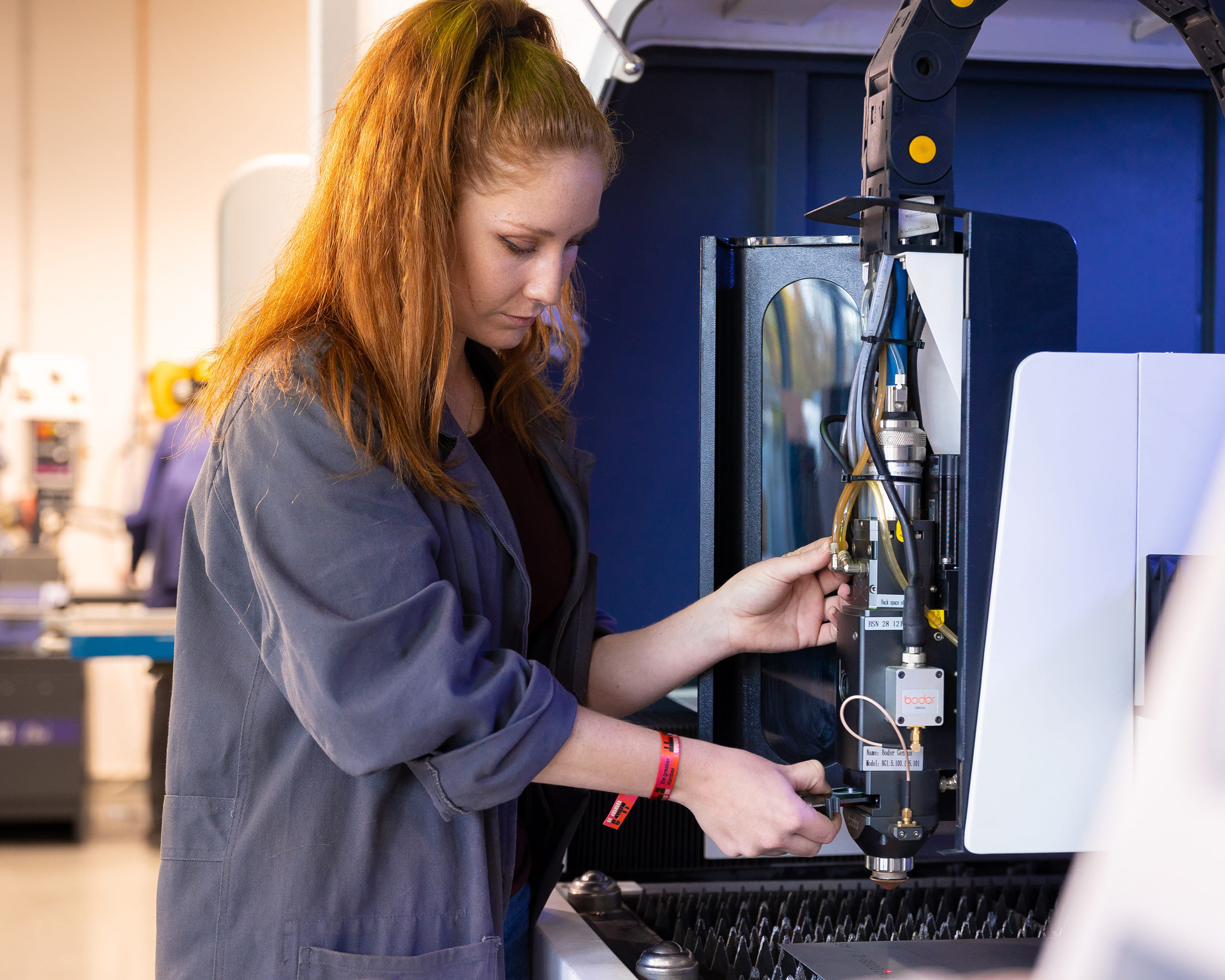 Een student werkt aan een geavanceerde machine in een technische werkplaats