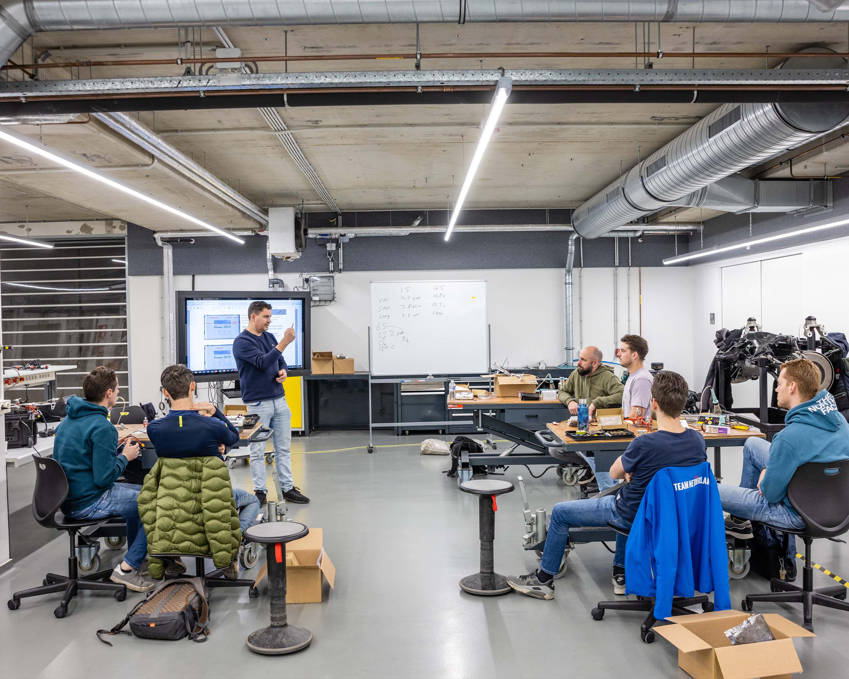 Leraar geeft instructies aan leerlingen technisch beroepsonderwijs