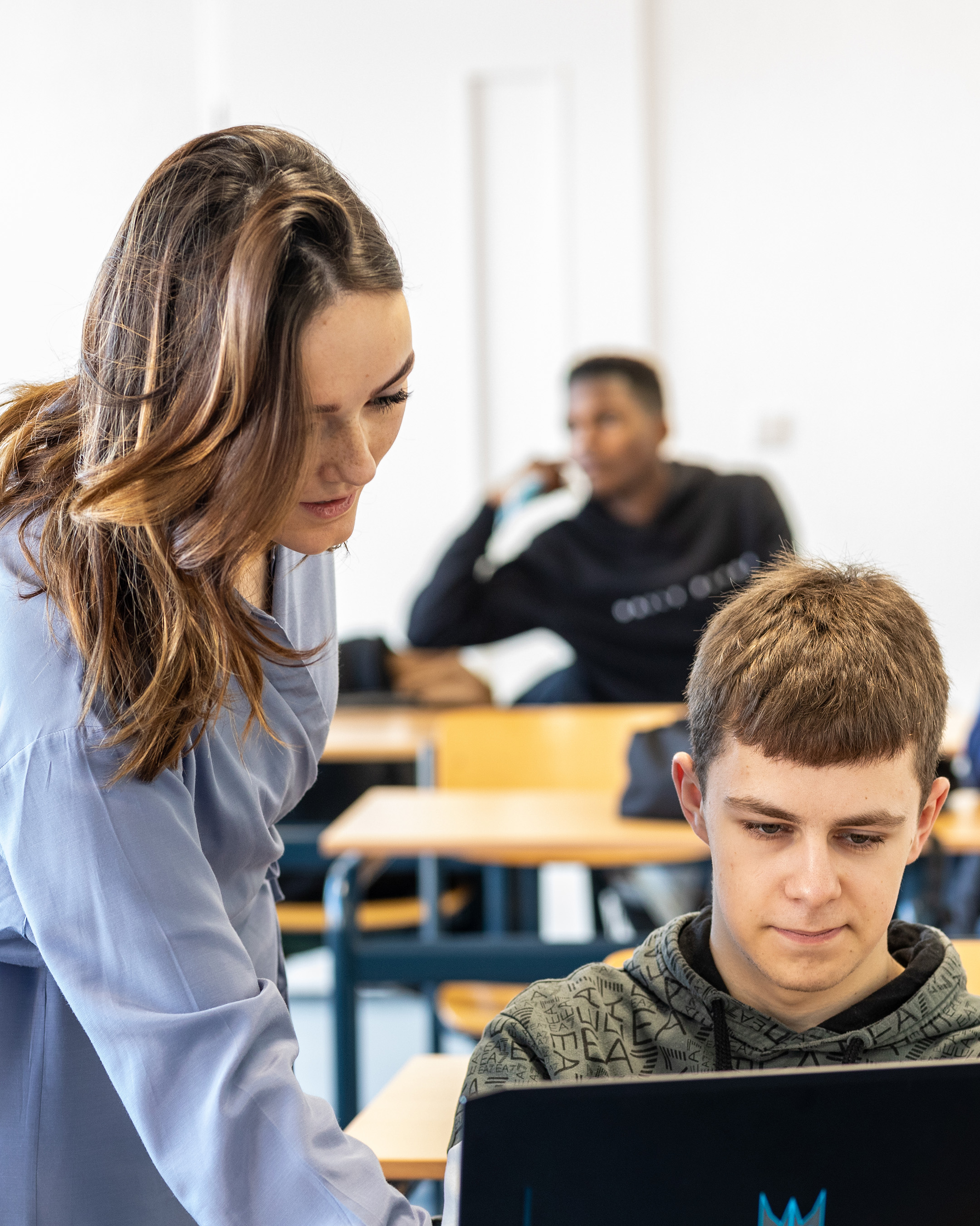 Masterstudent Leraar Nederlands helpt leerling met opdracht op laptop