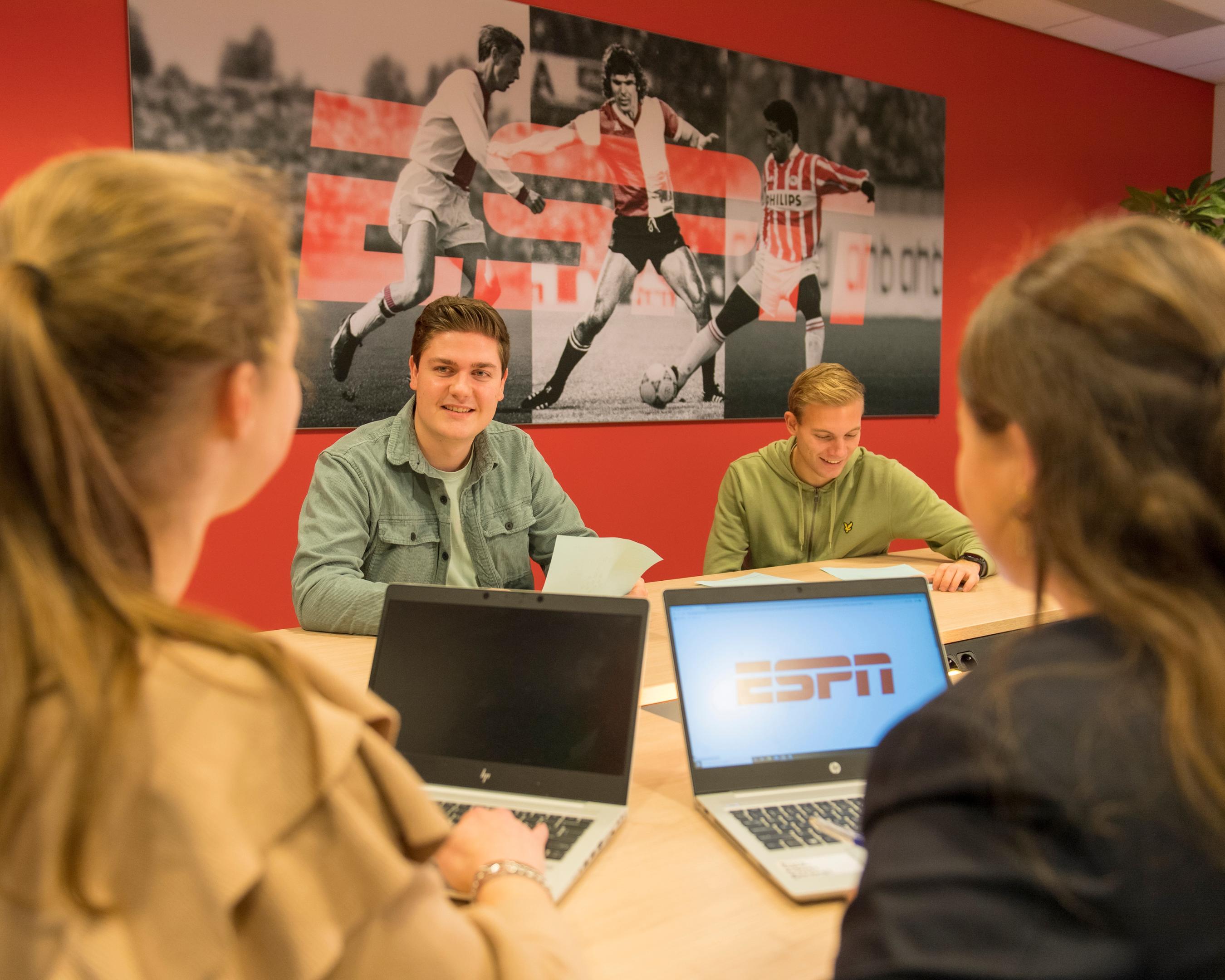 Vier studenten SPECO Sportcommunicatie hebben een bespreking aan tafel