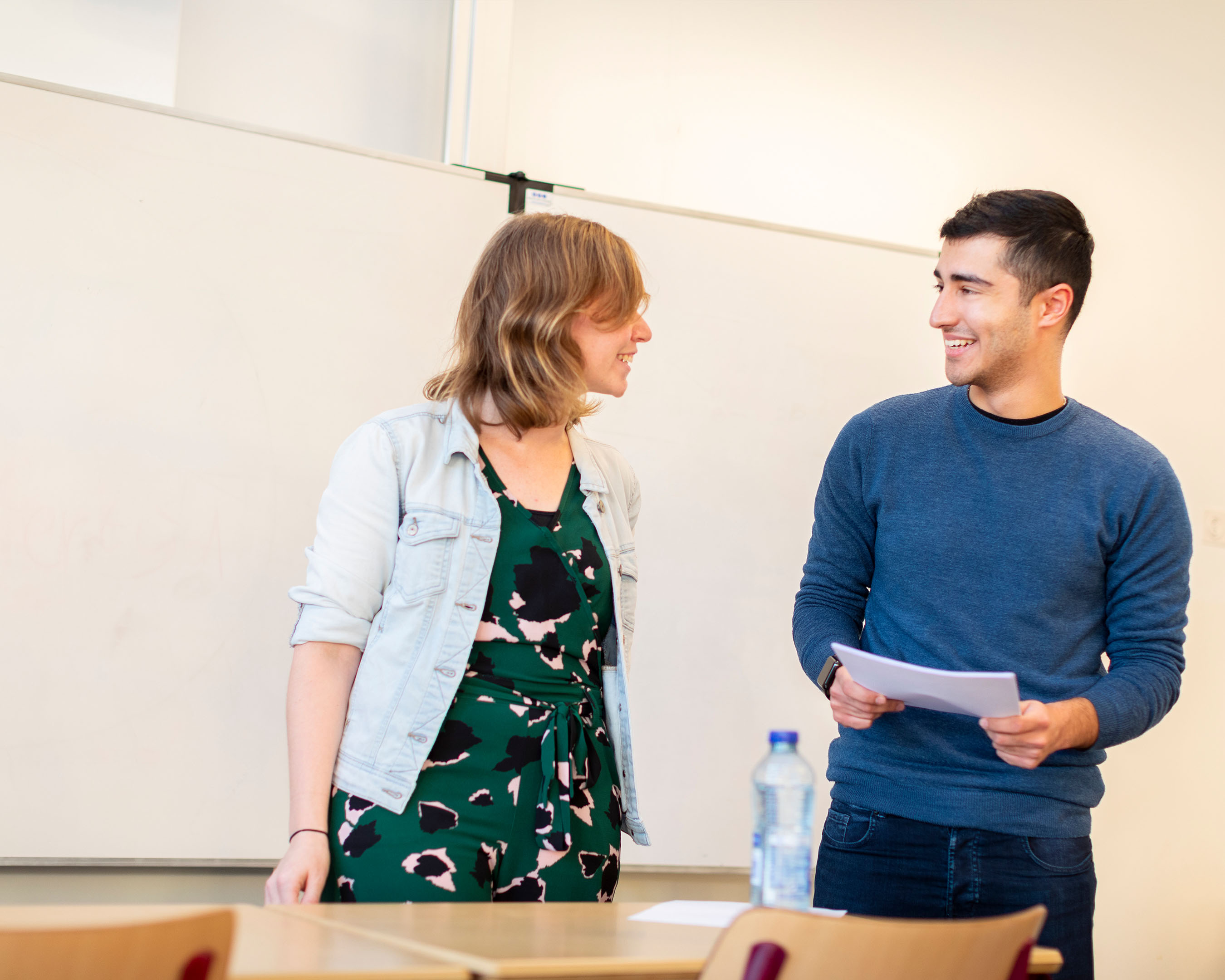 Student en docent staan voor de klas