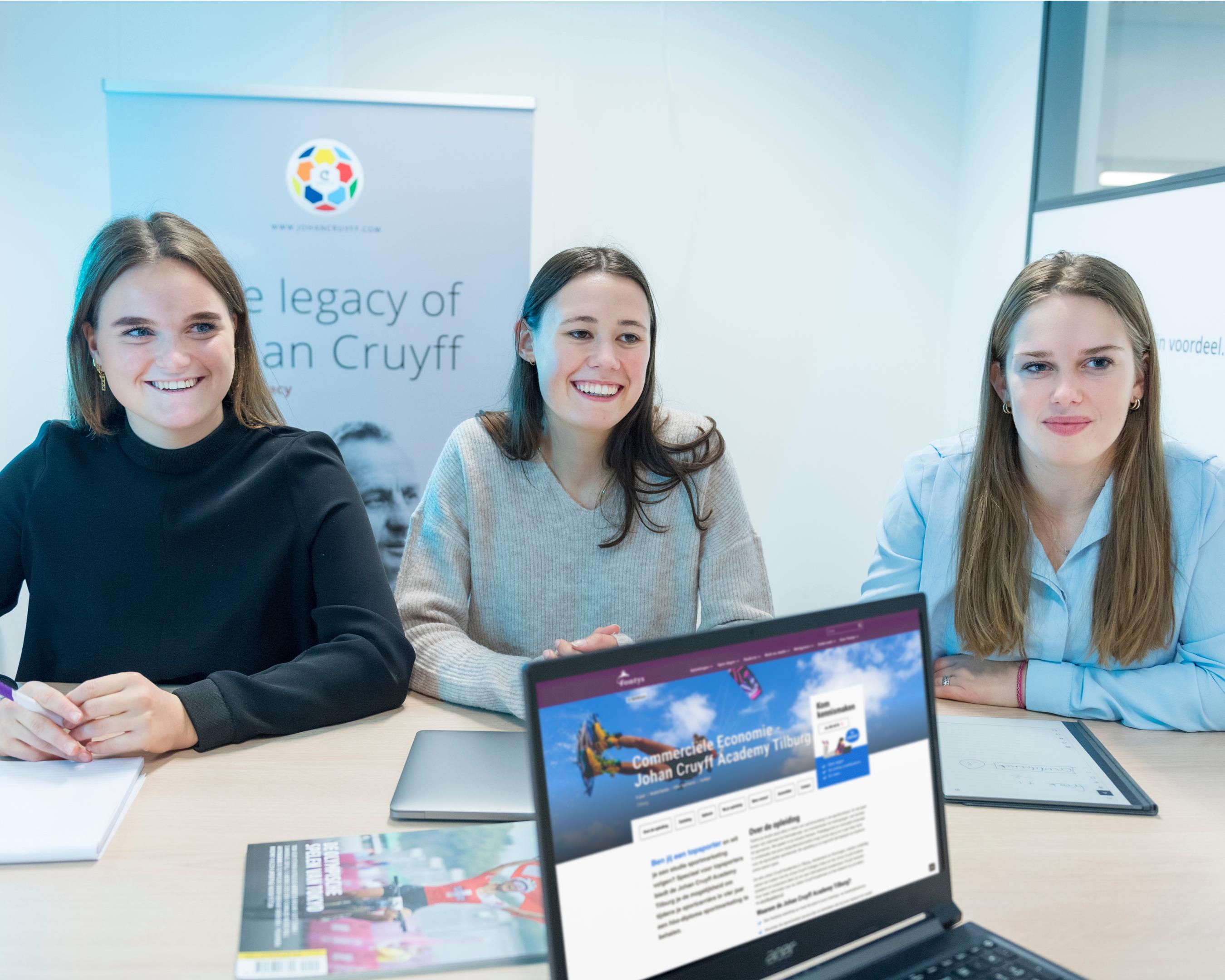 drie studenten zitten aan tafel