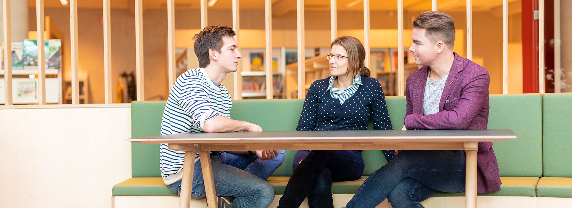 Drie volwassenen studenten met elkaar in gesprek