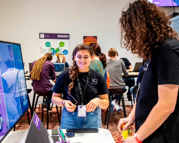 Lachende HBO-ICT studenten bekijken een project