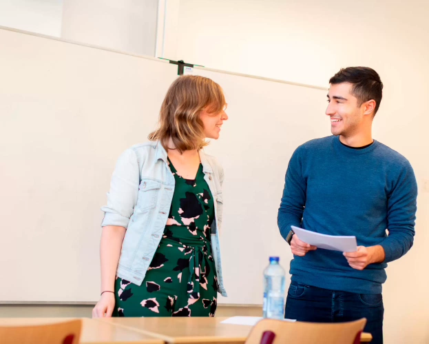 Student en docent staan voor de klas