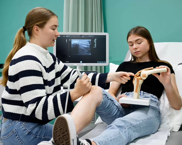 Twee studenten MBRT oefenen met echografie in een medische trainingsruimte.