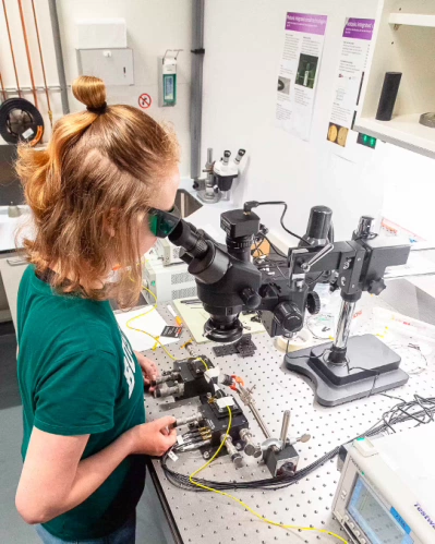 Student Technische Natuurkunde werkt met een microscoop