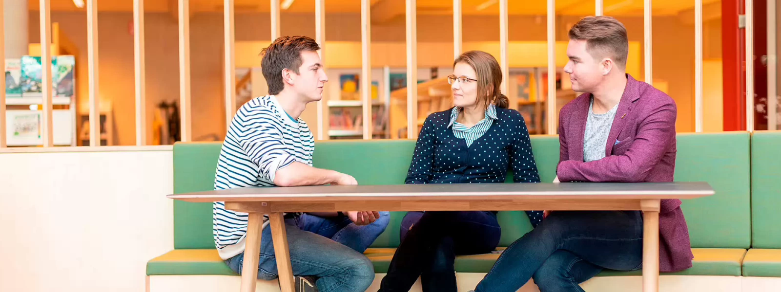 Drie volwassenen studenten met elkaar in gesprek