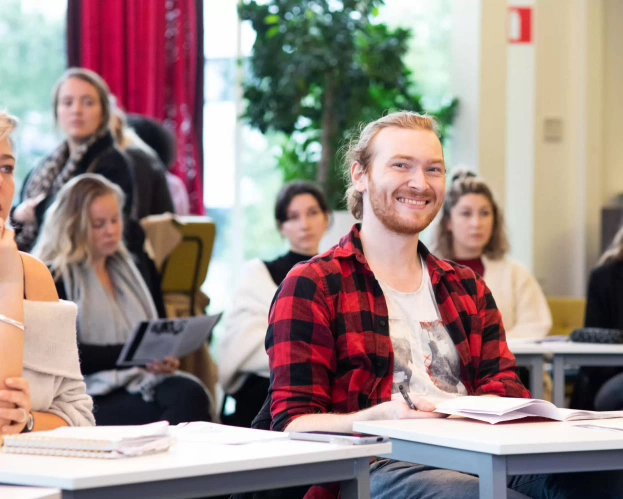 Studenten in de klas met boek op tafel voor de masteropleiding Leraar Engels