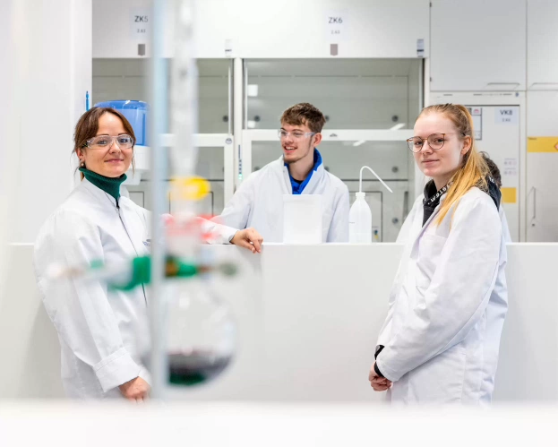 Three students in white lab coats