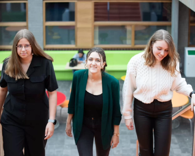 Studenten zitten in de studieruimte en zijn aan het overleggen.