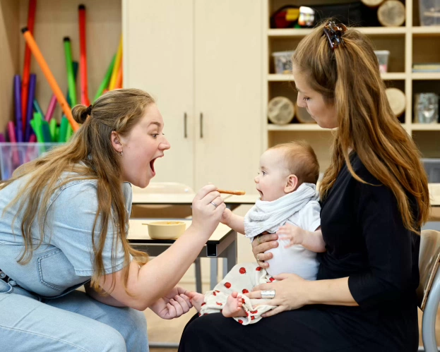 Student Logopedie helpt een baby.