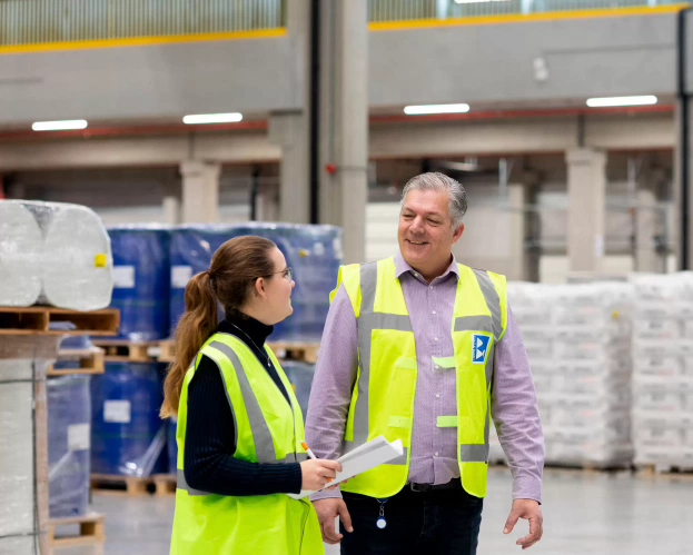 Student logistiek op een bedrijfslocatie in gesprek met werknemer