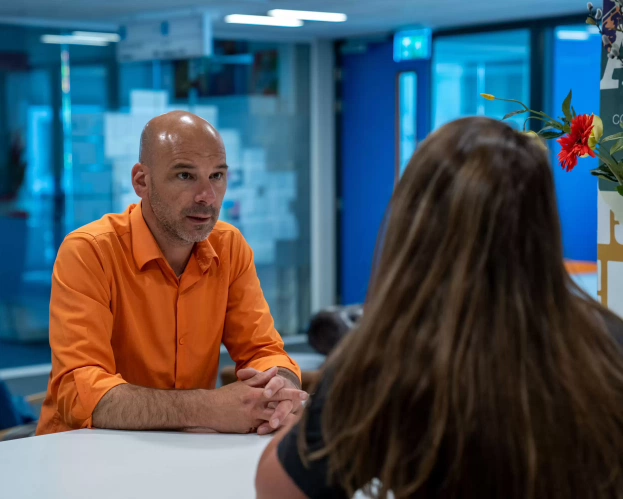 Twee studenten praten aan tafel