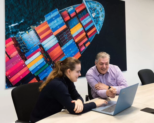 Student and teacher discuss coursework together on laptop