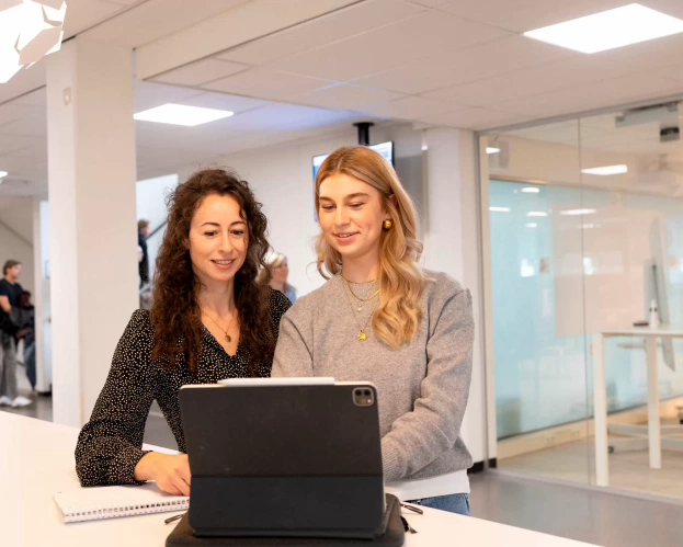 Two students looking at a laptop