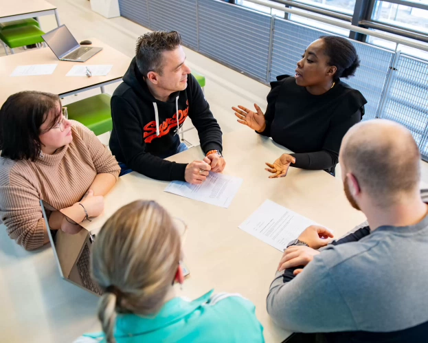 Een groep studenten rondom een tafel