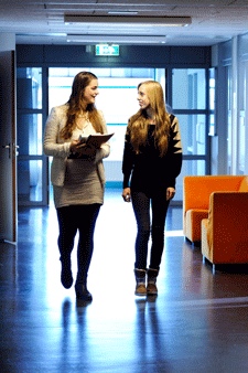 2 meisjes lopen door een gang van een schoolgebouw